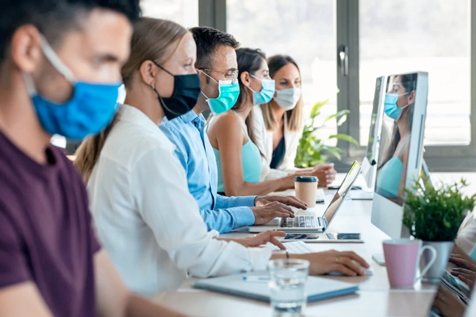 Plusieurs personnes travaillent avec un masque chirurgical